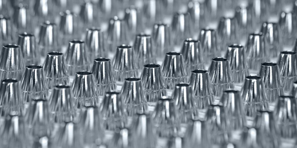 Reihen kegelförmiger Kleinteile mit glänzender Oberfläche bei Jander Galvanik in Iserlohn